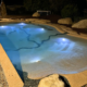 Bio.design-Pool in stimmungsvoller Abendbeleuchtung mit Randbepflanzung