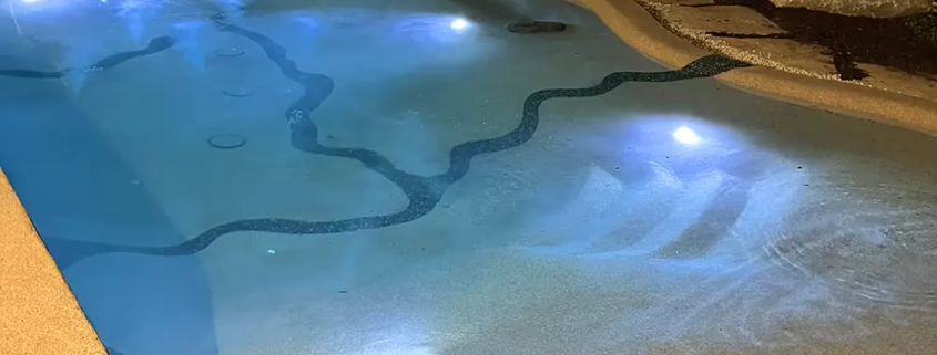 Bio.design-Pool in stimmungsvoller Abendbeleuchtung mit Randbepflanzung