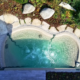 Bio.design-Pool in geschwungener Form mit Randbepflanzung und großen Steinen