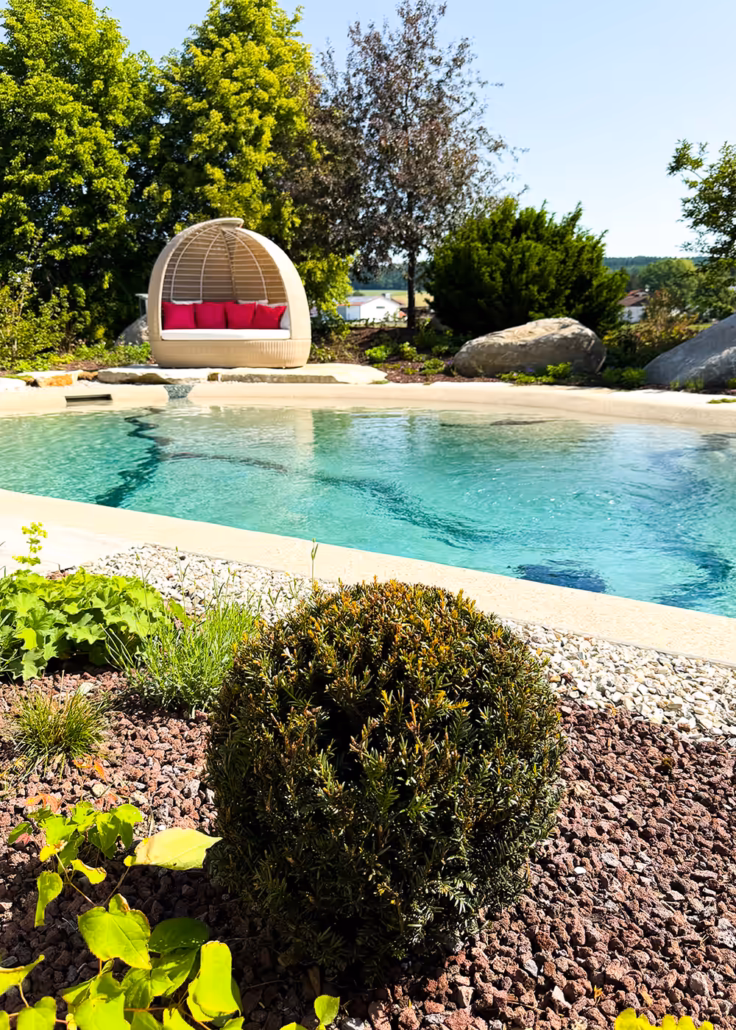 Natürlicher Bio.design-Pool mit bequemem Daybed – entspanntes Poolerlebnis im naturnahen Ambiente