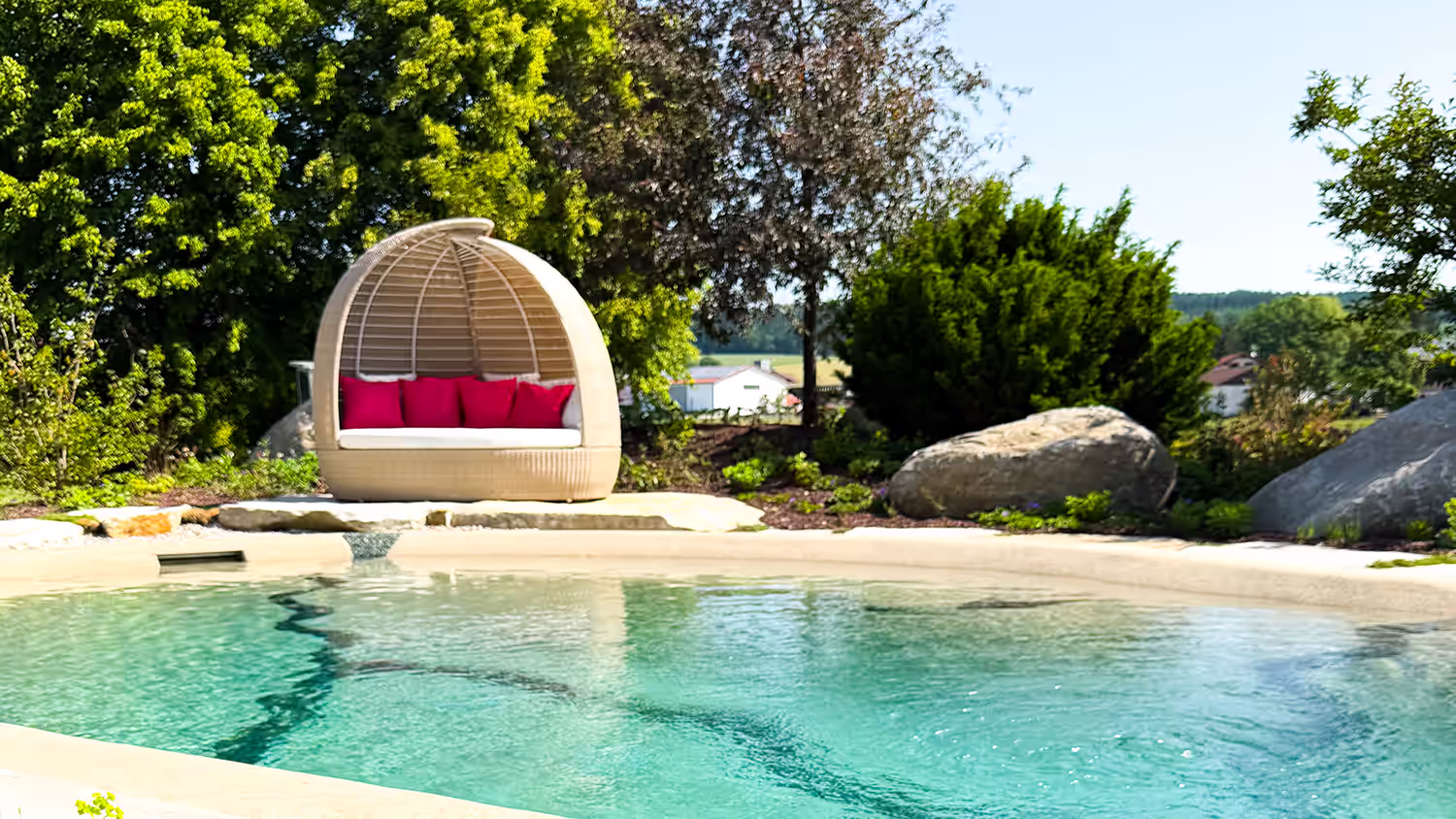 Natürlicher Bio.design-Pool mit bequemem Daybed – entspanntes Poolerlebnis im naturnahen Ambiente