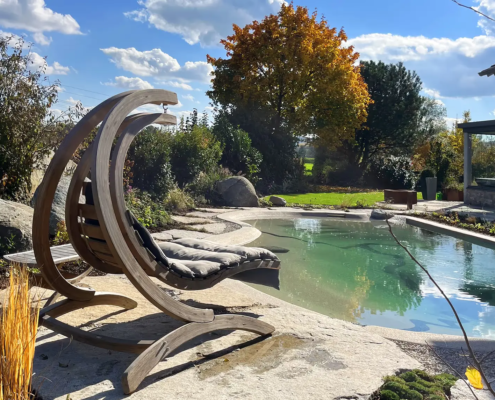 Bio.design-Pool mit Gartenbepflanzung und Hängeschaukel aus Holz