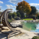 Bio.design-Pool mit Gartenbepflanzung und Hängeschaukel aus Holz