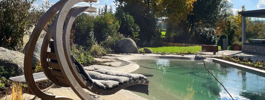 Bio.design-Pool mit Gartenbepflanzung und Hängeschaukel aus Holz