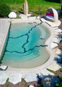 Natürlicher Designerpool mit gemütlicher Sitzgelegenheit und Außendusche