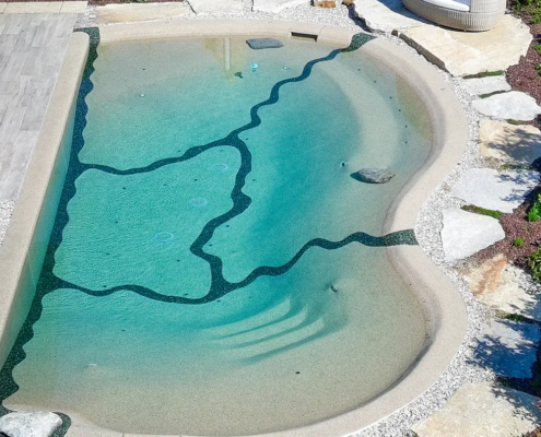 Natürlicher Designerpool mit gemütlicher Sitzgelegenheit und Außendusche